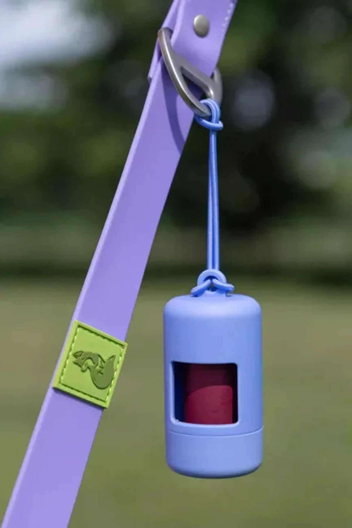 “Aria the Fox Cornflower Blue dog waste bag dispenser with bungee attachment.”